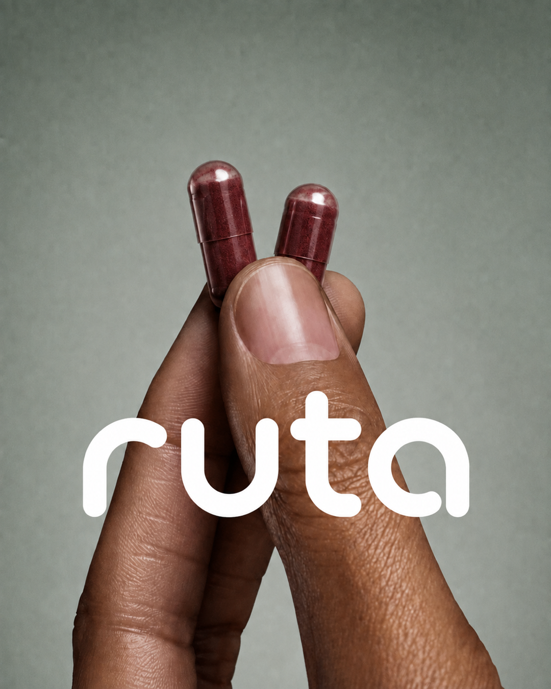 Hand holding two beetroot capsules with the Ruta logo
