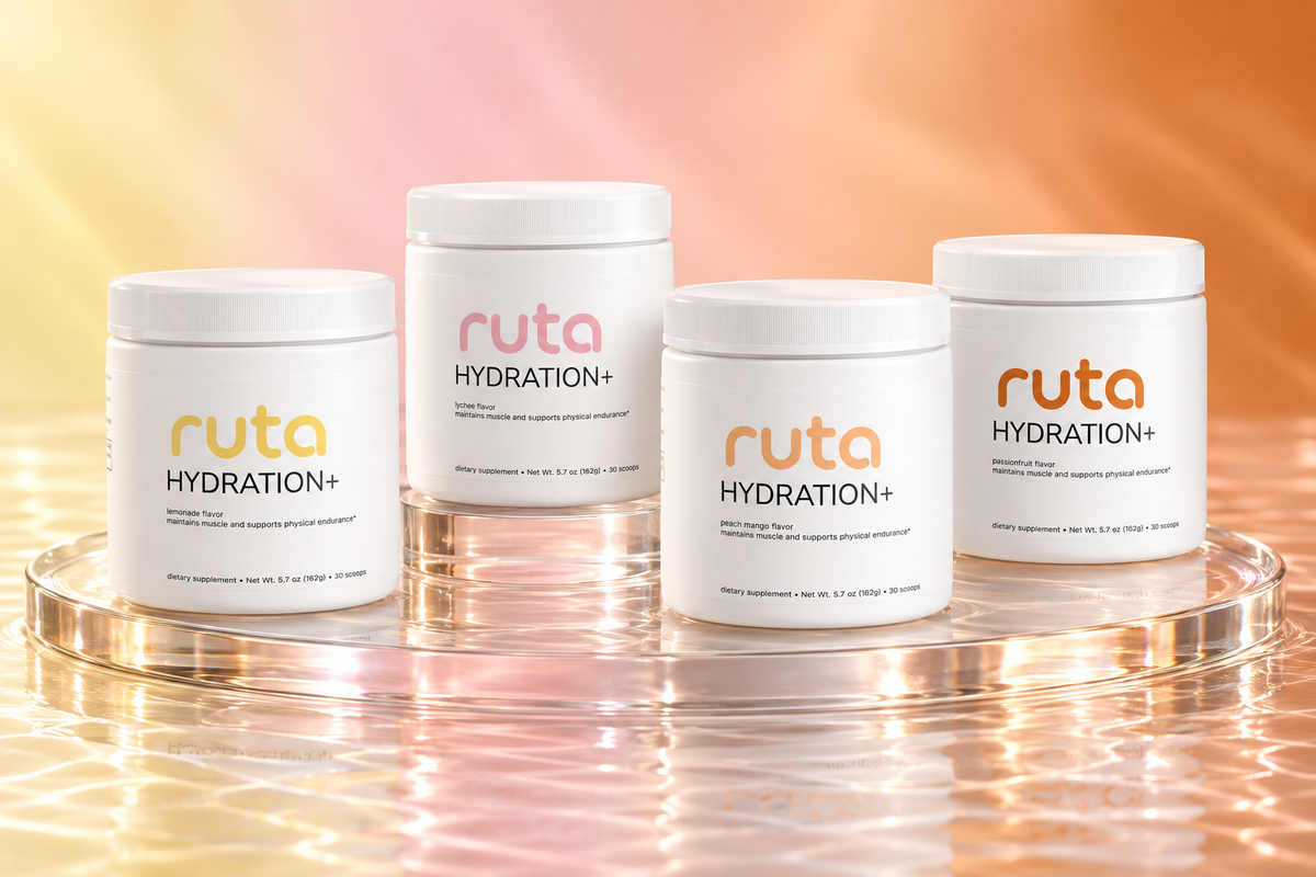 Ruta Hydration+ in Lemonade, Lychee, Peach Mango and Passion Fruit on a glass platform in soft pastel light